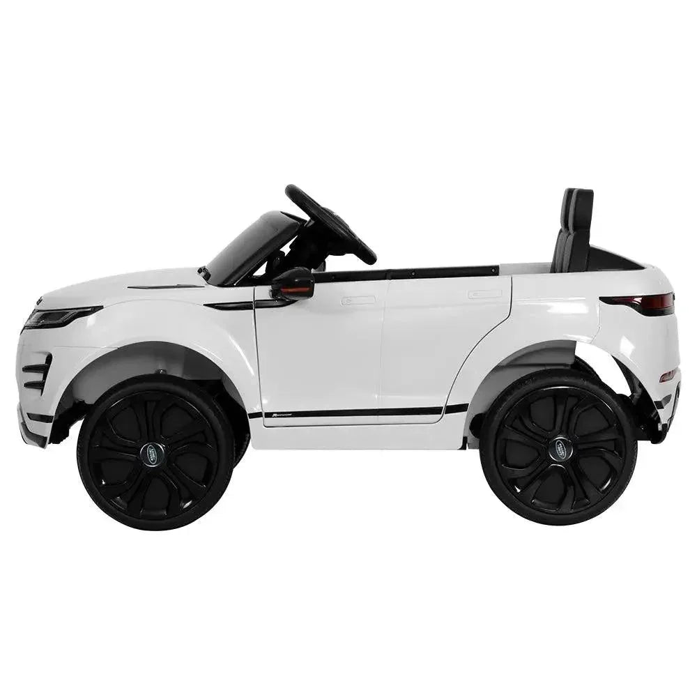 Close-up of dashboard and steering wheel inside white ride on Land Rover toy car.