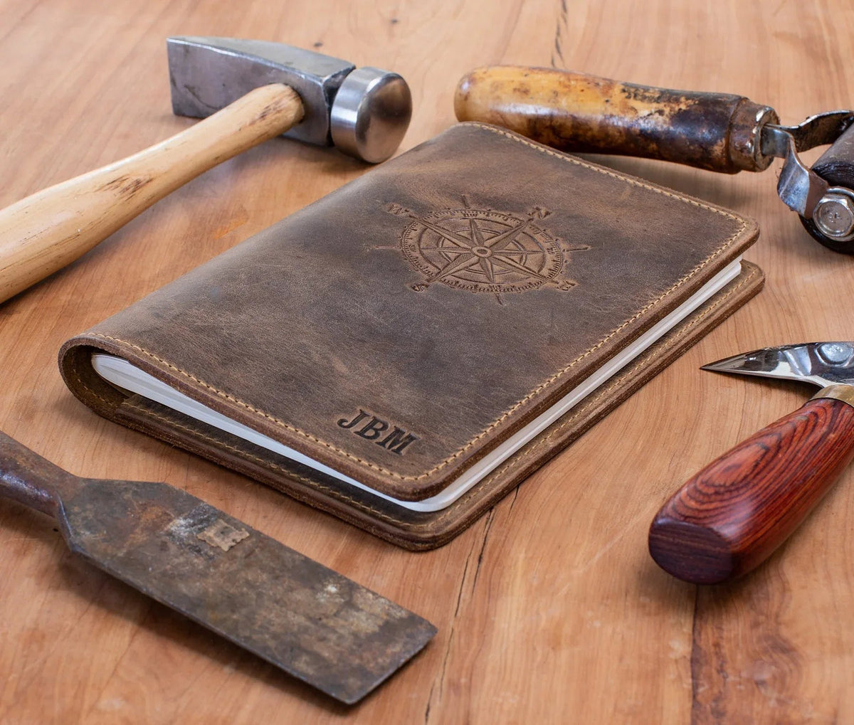 Top view of Old West design leather journal closed on wooden surface