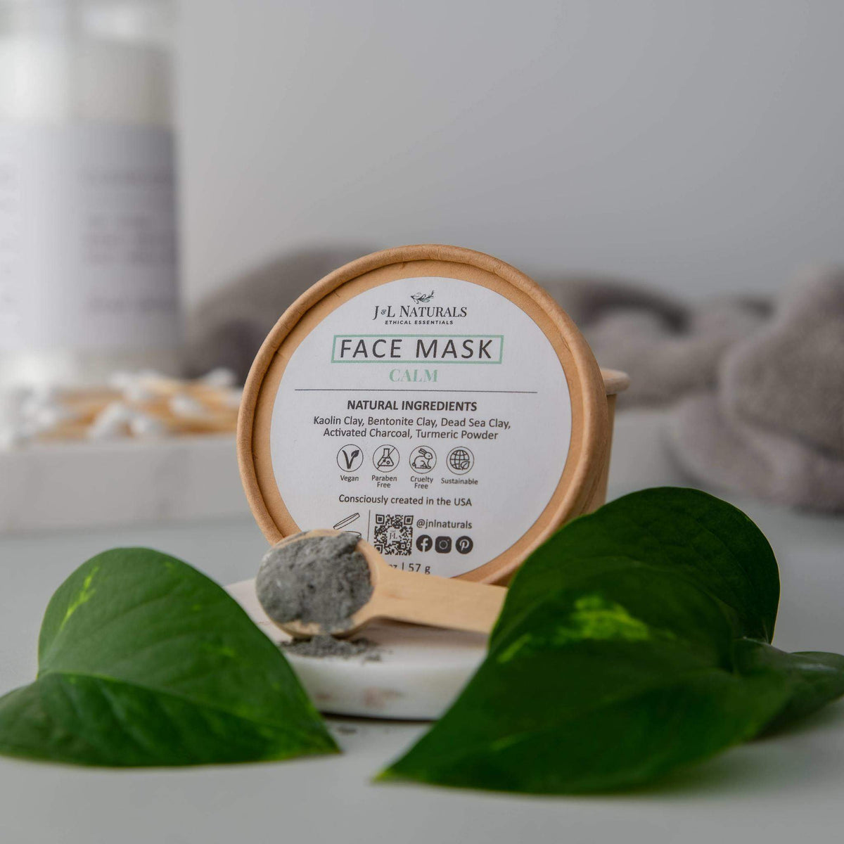 Woman applying calm face mask on cheeks in a bright, relaxed home setting.