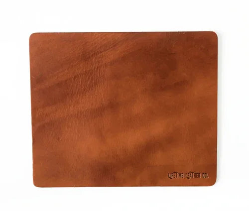 Close-up of light brown leather mouse pad emphasizing natural leather texture and edges.