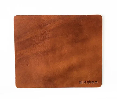 Light brown leather mouse pad displayed on white background showing smooth surface.