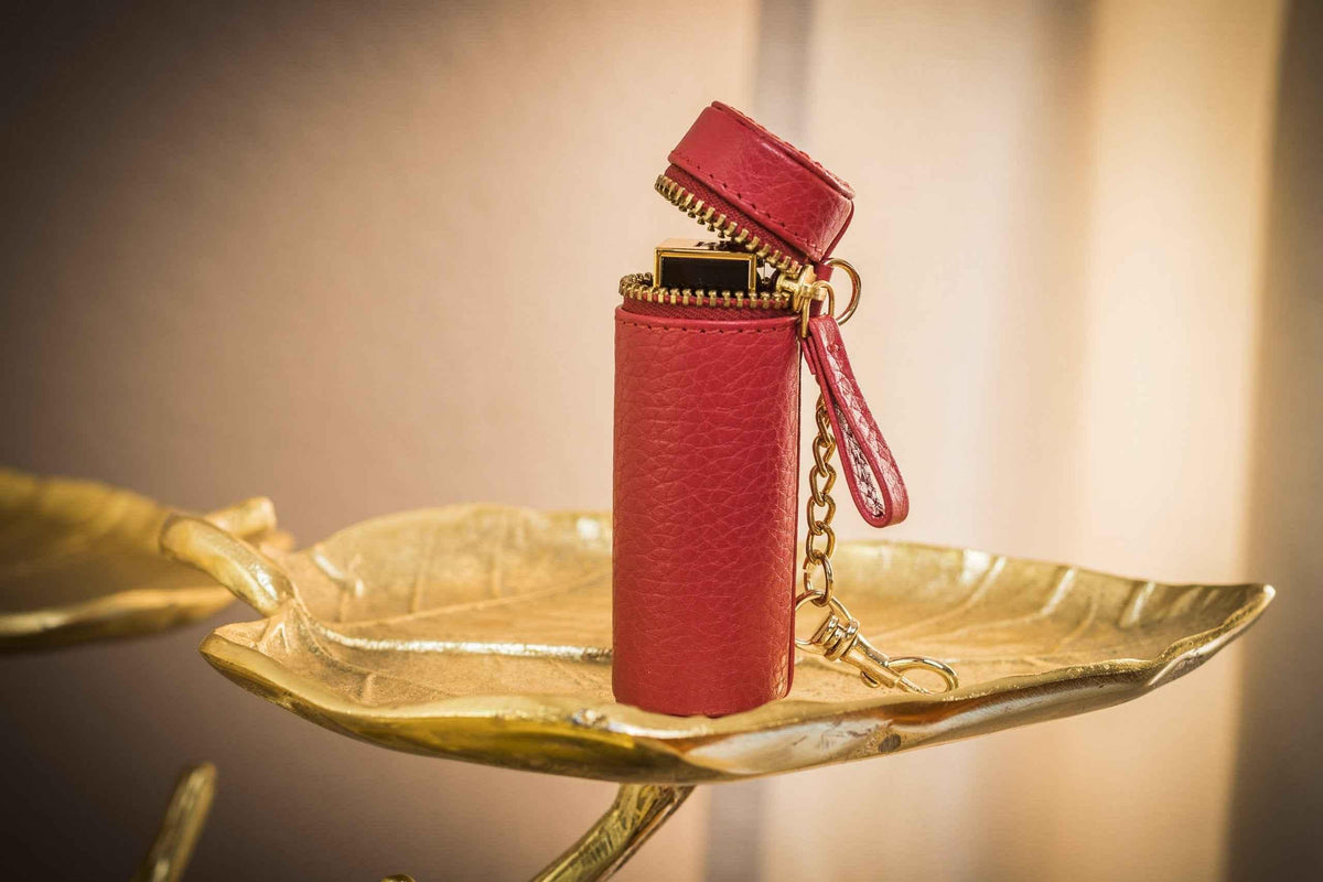 Leather lipstick pouch attached to a handbag strap with metal clasp