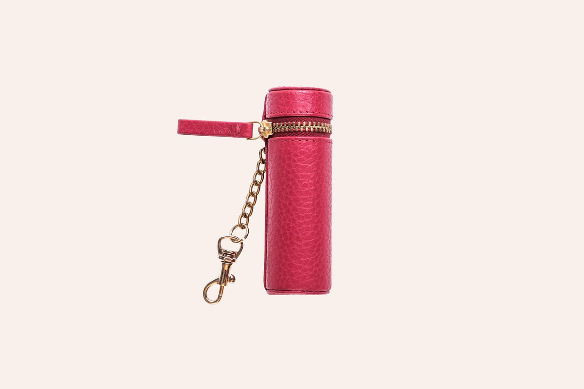 Lipstick keeper pouch beside a tube of lipstick on wooden surface