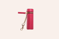 Lipstick keeper pouch beside a tube of lipstick on wooden surface