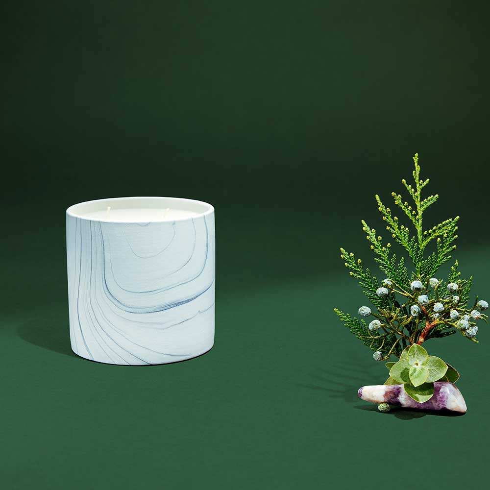 Close-up of marble ceramic candle vessel showing detailed white and gray swirls.