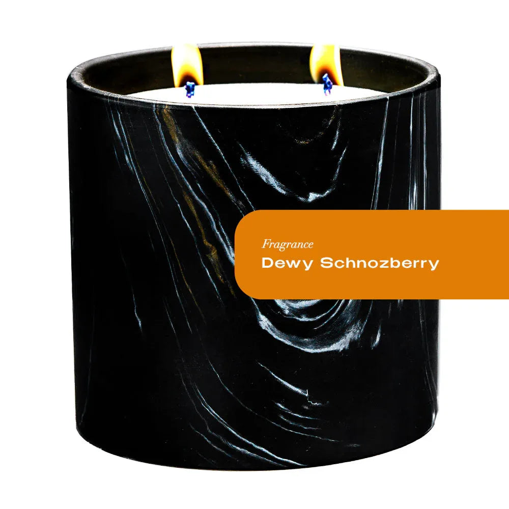 Close-up of Dewy Schnozberry candle in black and white marquina ceramic vessel with gold swirls.