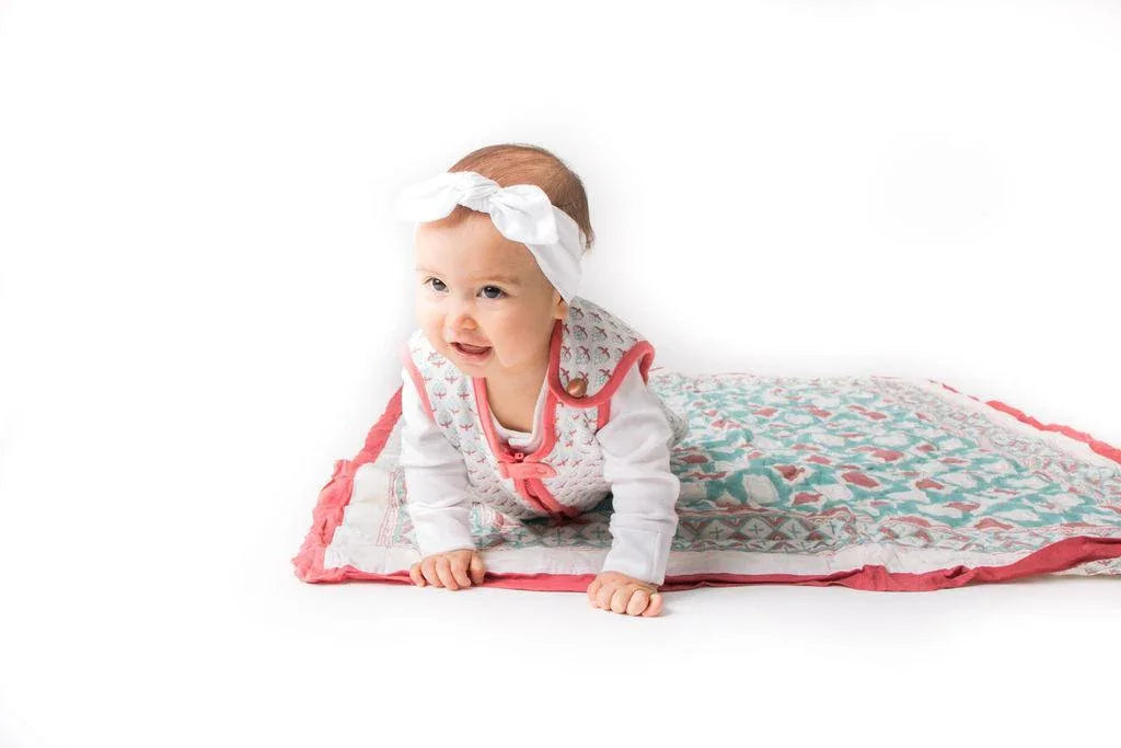 Beige wearable baby sleep bag shown zipped up on flat surface.