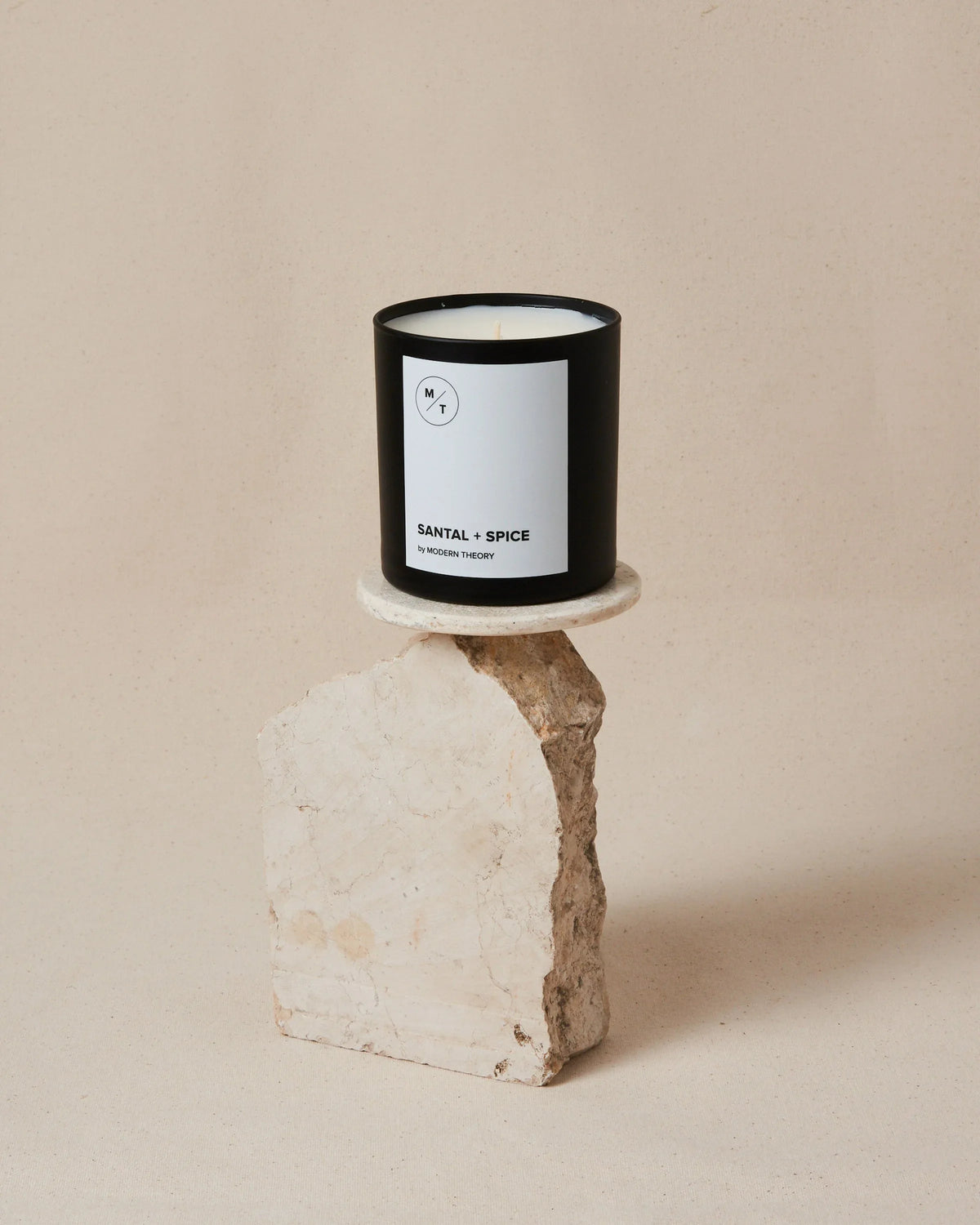 SANTAL + SPICE candle in glass jar with wooden lid on a neutral surface, showing elegant minimalist label.