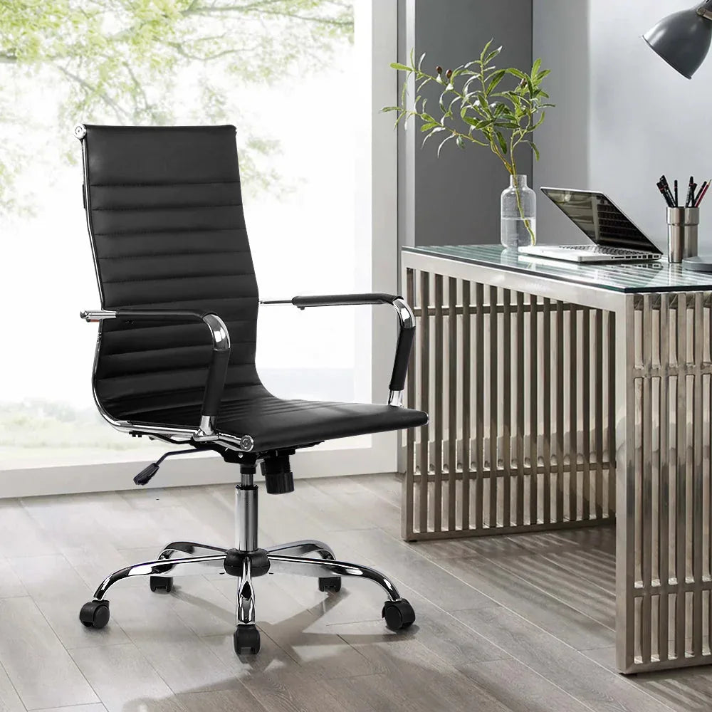 Black office chair placed in home office setup with computer desk and accessories.