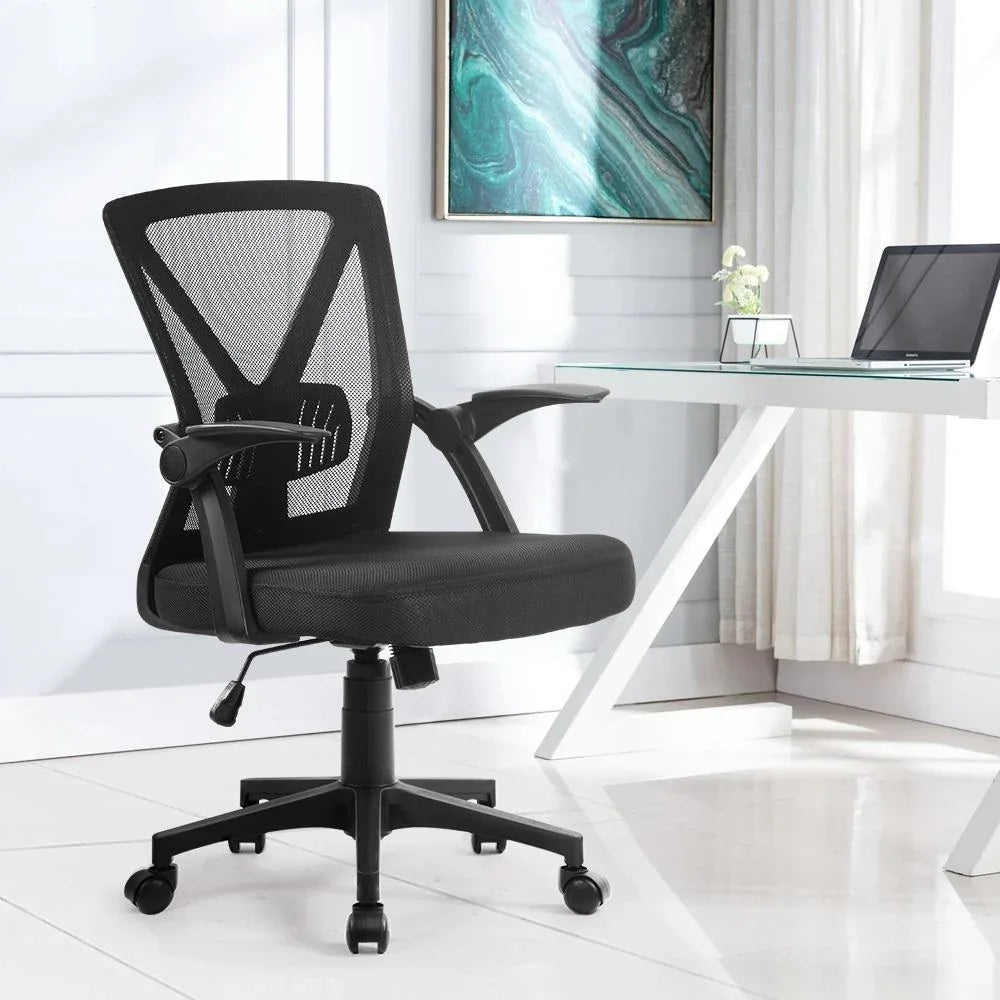 Low angle showing base and wheels of a black ergonomic mesh office chair in a studio setting.