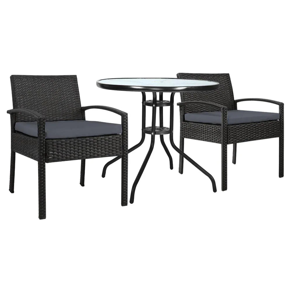 Two wicker garden patio chairs with beige cushions around a glass-top outdoor table.