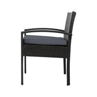 Glass-top outdoor table with wicker chairs arranged for outdoor dining.