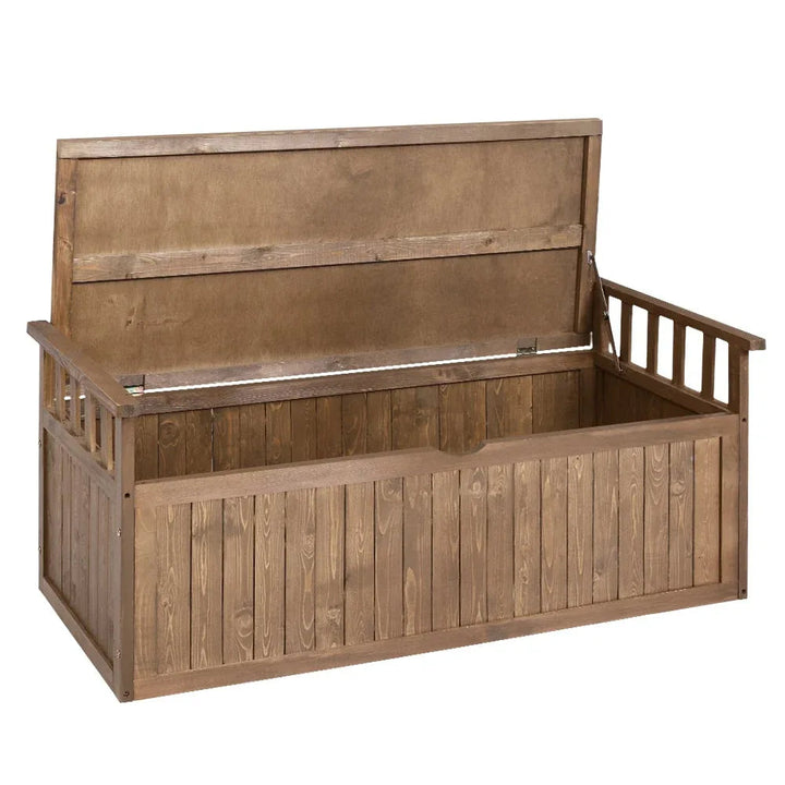 Outdoor wooden storage bench with hinged seat in natural fir wood on stone patio