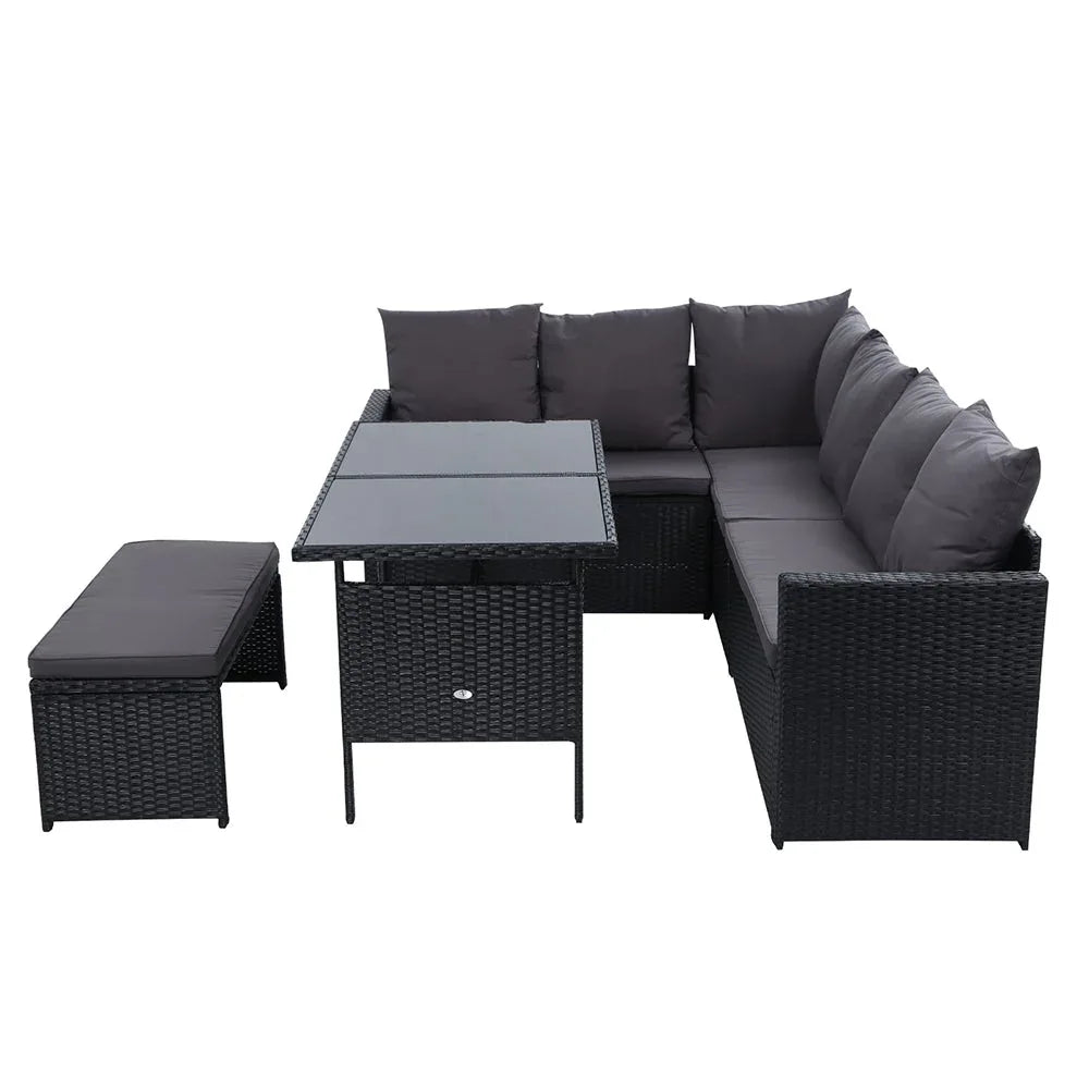 Outdoor sectional sofa with black wicker frame and soft cushions arranged on wooden patio