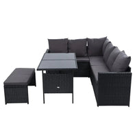 Outdoor sectional sofa with black wicker frame and soft cushions arranged on wooden patio
