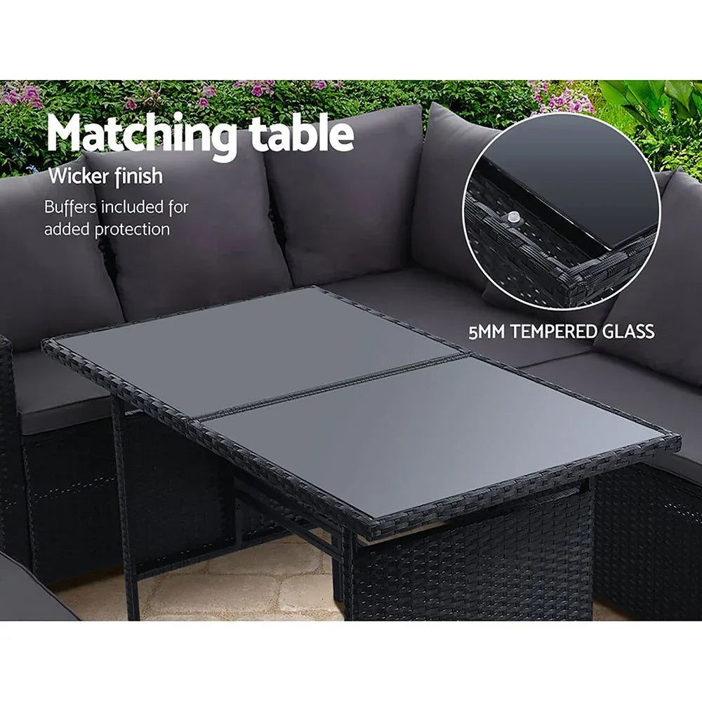 Wide angle view of black wicker 9-seater outdoor sofa set arranged in garden setting