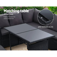 Wide angle view of black wicker 9-seater outdoor sofa set arranged in garden setting
