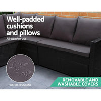 Outdoor furniture set with black wicker sofa pieces and beige cushions on stone patio