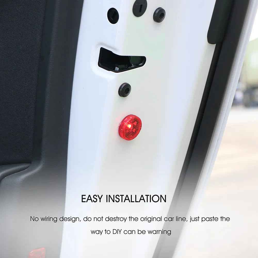 Wireless car door warning light pair glowing red, attached to open car door at night for increased safety.