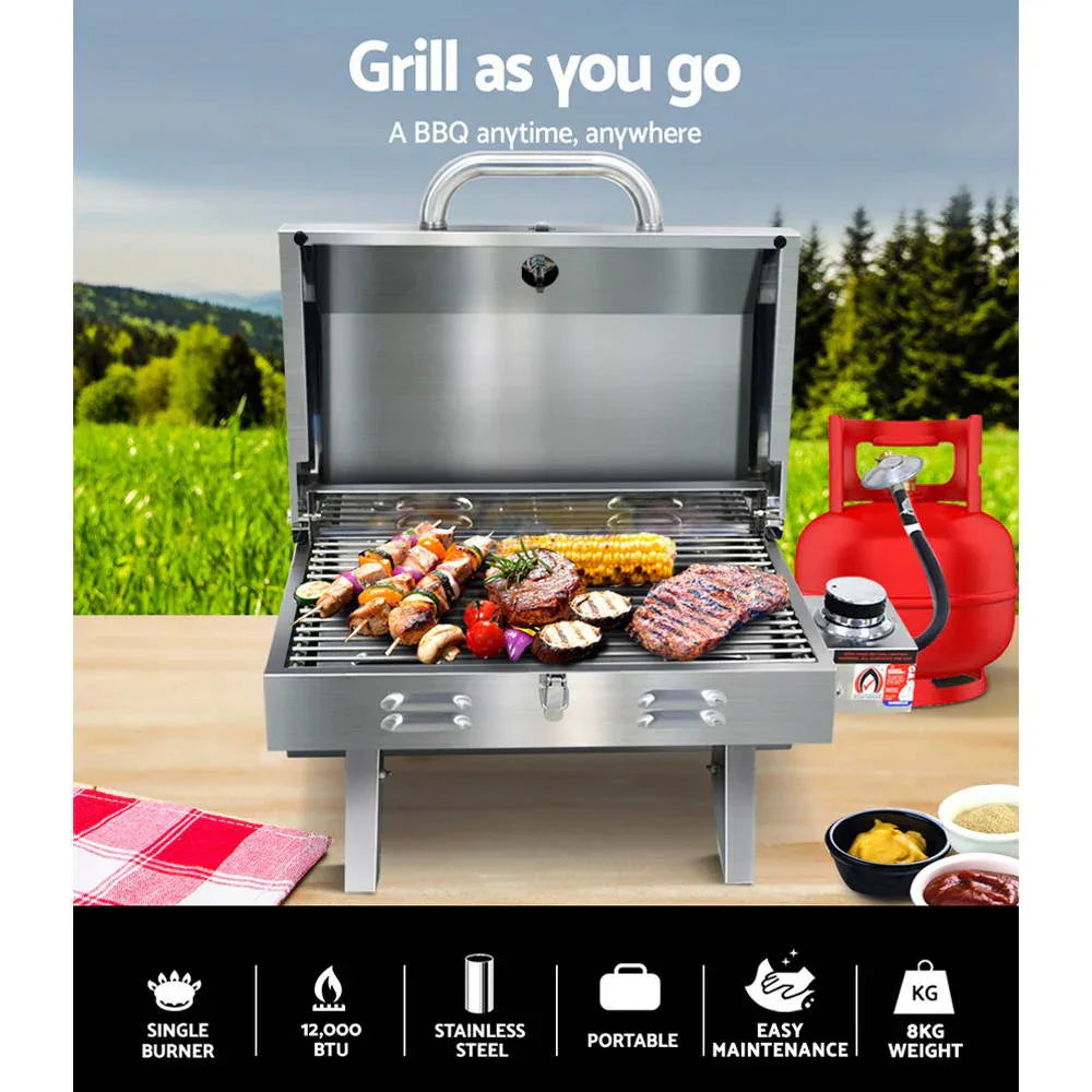 Open view of stainless steel portable BBQ grill with burner, integrated thermometer, and flame tamer.