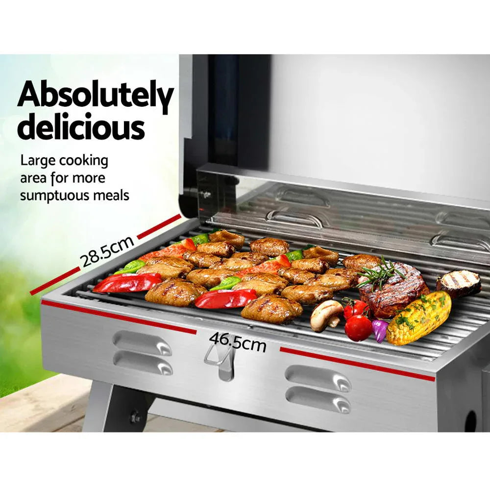 Folded portable gas BBQ grill leaning on its side, highlighting compact and durable design.