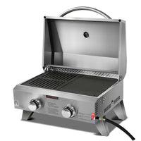 Top view of two-burner portable gas BBQ stove with stainless steel finish and locking lid closed.