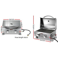 Portable gas BBQ grill opened showing two burners, side handles, and integrated thermometer on lid.