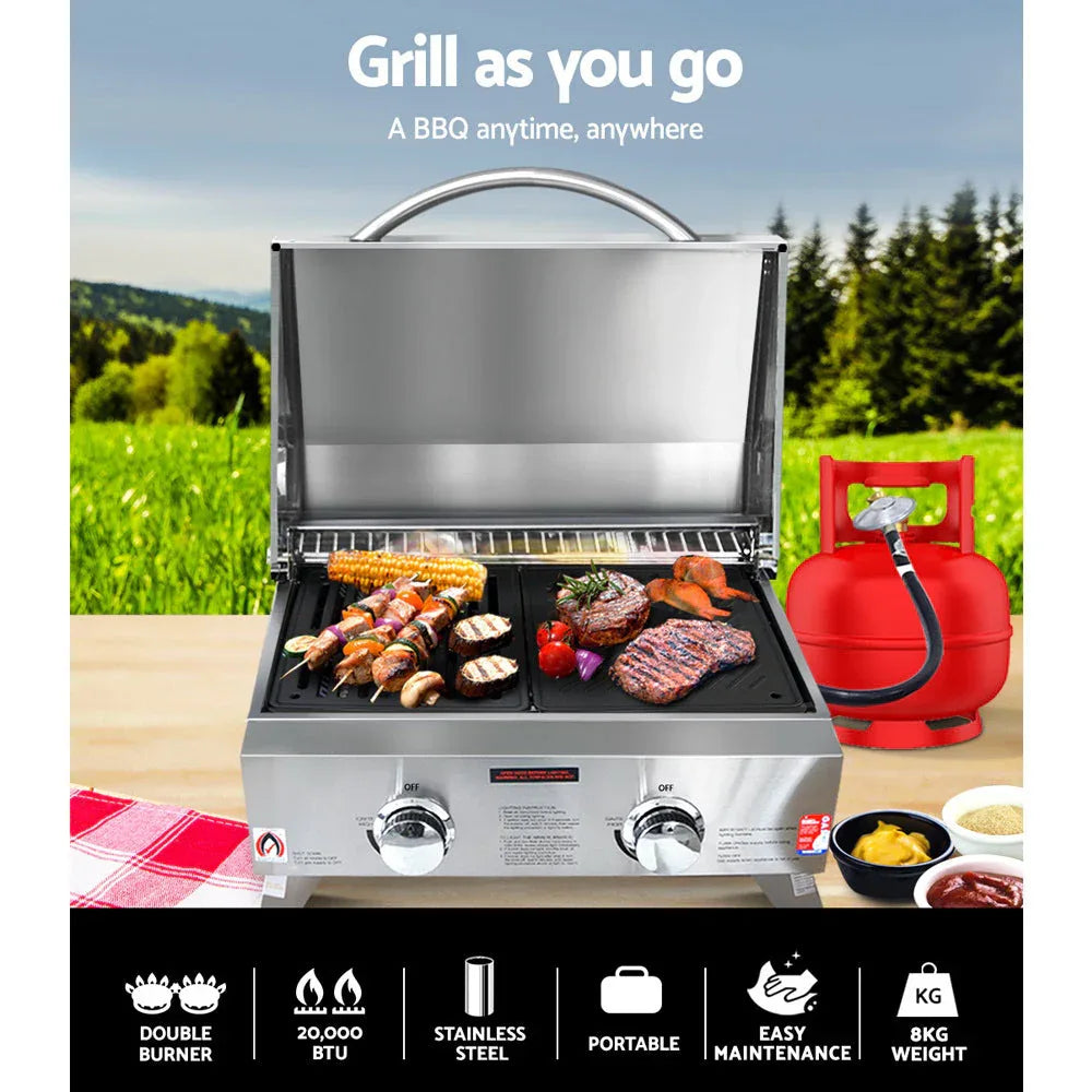 Side view of portable gas BBQ oven with foldable legs extended and front carry handle.