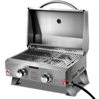 Closed portable 2 burner stainless steel gas BBQ with carry handle on a white background.