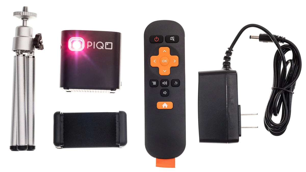 Close-up of PIQO projector showing buttons and lens on its compact, cube-shaped body.