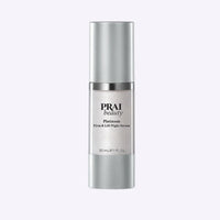 Bottle of PRAI Beauty Platinum Night Caviar Firm & Lift Serum with elegant white and silver packaging