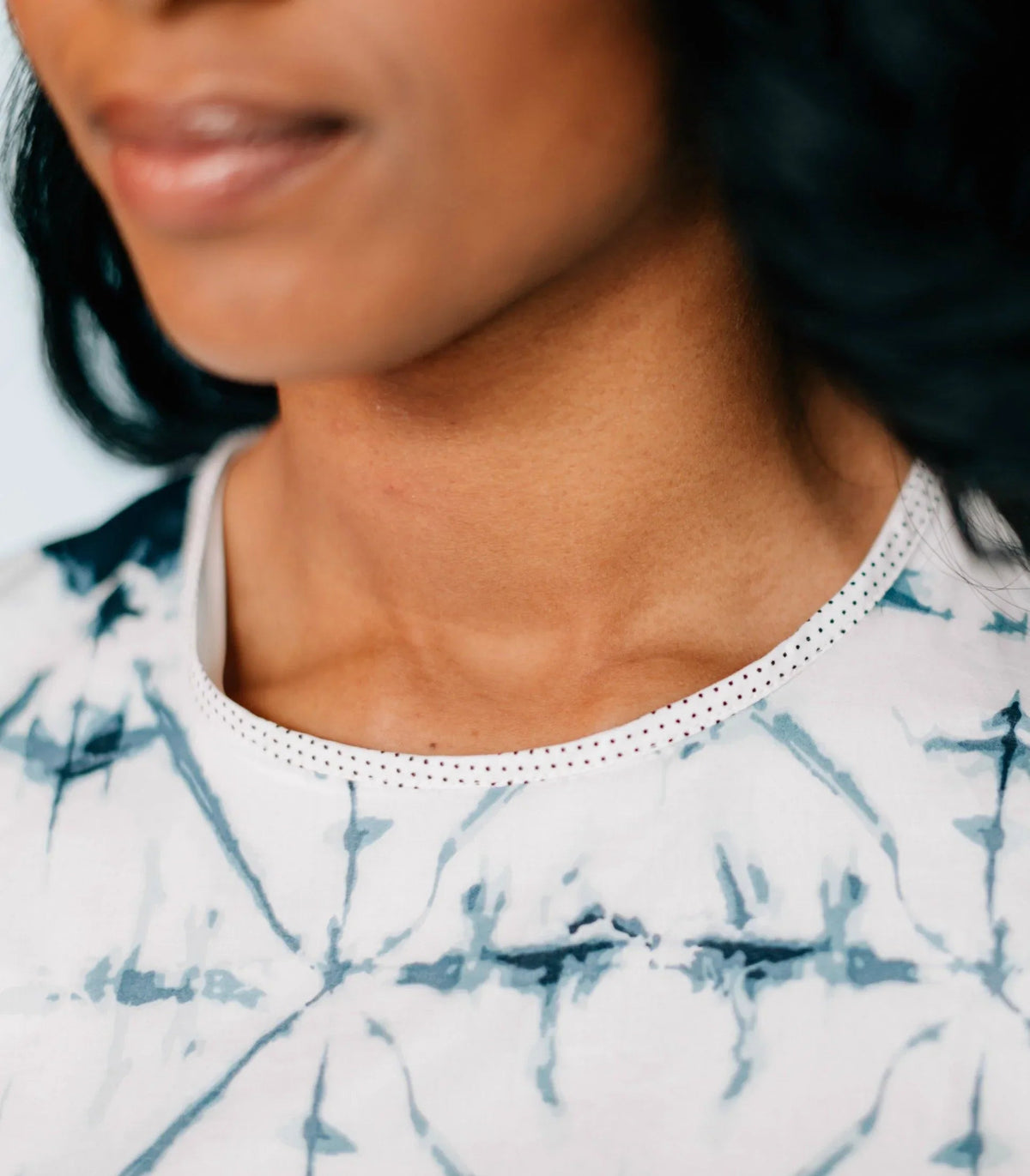 Portrait of model in Inkwell Dress smiling with relaxed pose against neutral background.