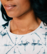 Portrait of model in Inkwell Dress smiling with relaxed pose against neutral background.