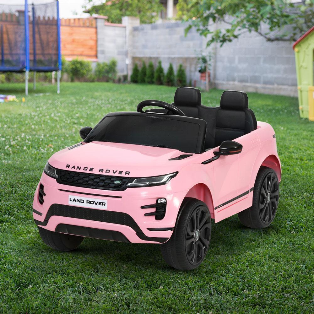 Close-up of rear wheel and side step of the red kids electric ride-on Land Rover Evoque car toy