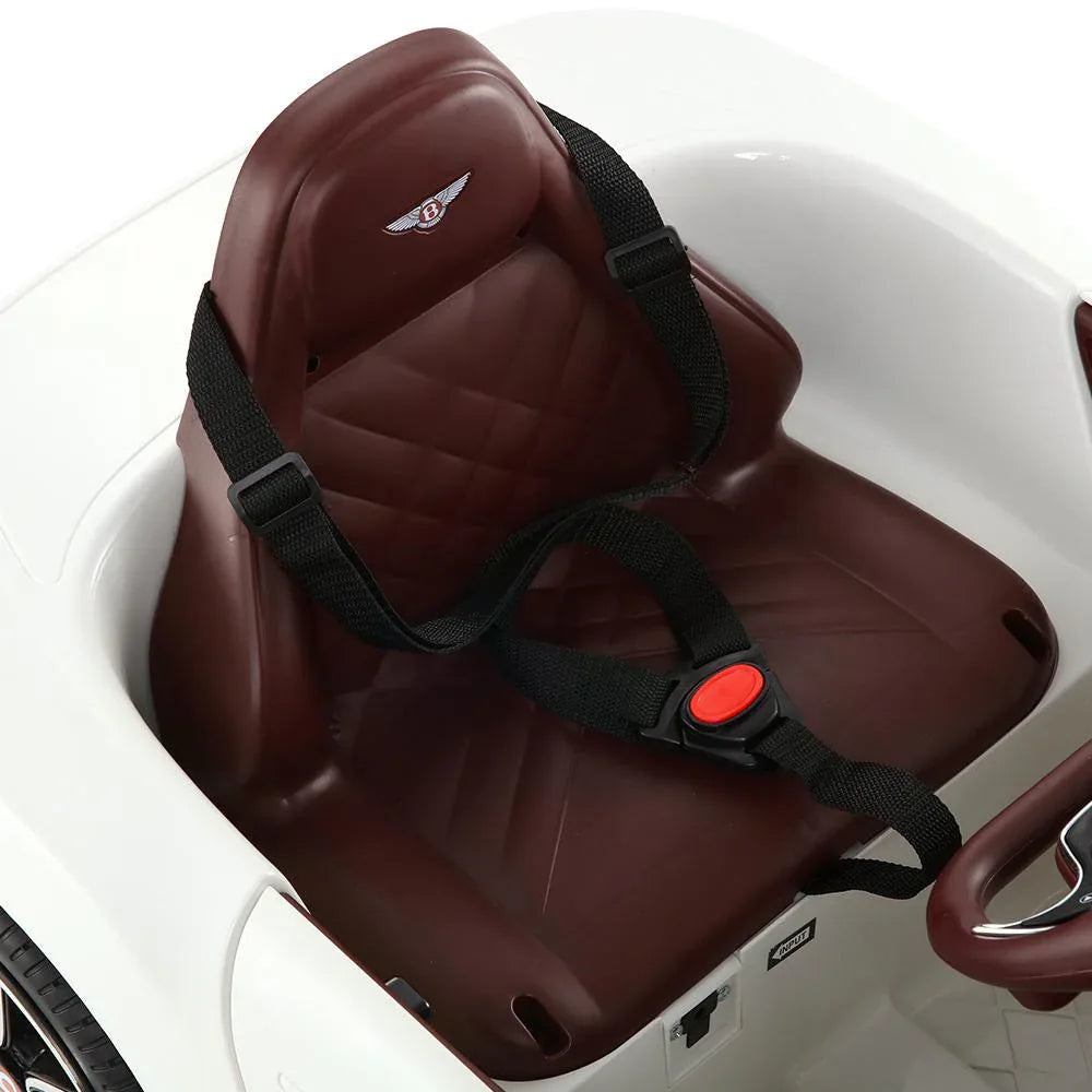 Interior view showcasing dashboard and steering wheel of white Bentley electric ride on toy.