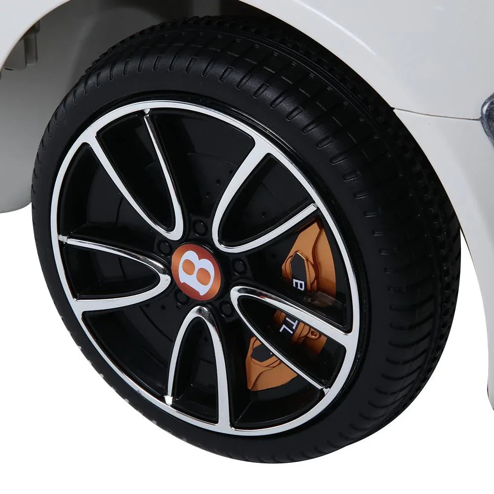 White electric kids car positioned outdoors with open side door and realistic features.