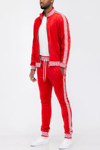 Red and white velour track set featuring full zip jacket and elastic cuff pants displayed flat.