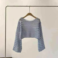 Back view of white crochet crop top highlighting delicate knit design.