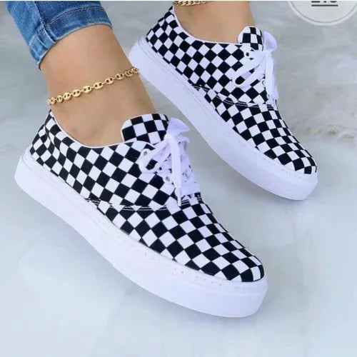 White women's sneakers with colorful graffiti designs, lace-up front, and chunky rubber soles displayed on a white.
