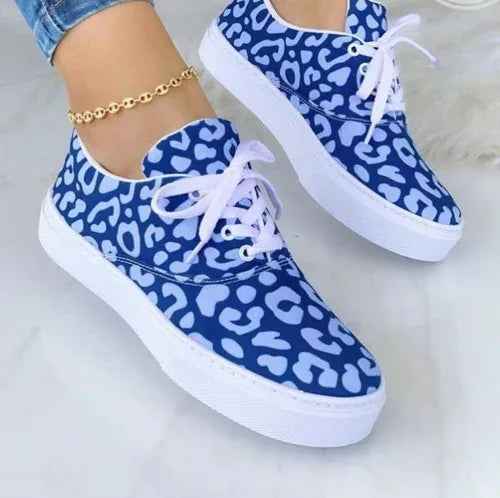 Women's white sneakers with colorful graffiti-style designs on the sides, shown against a neutral background.