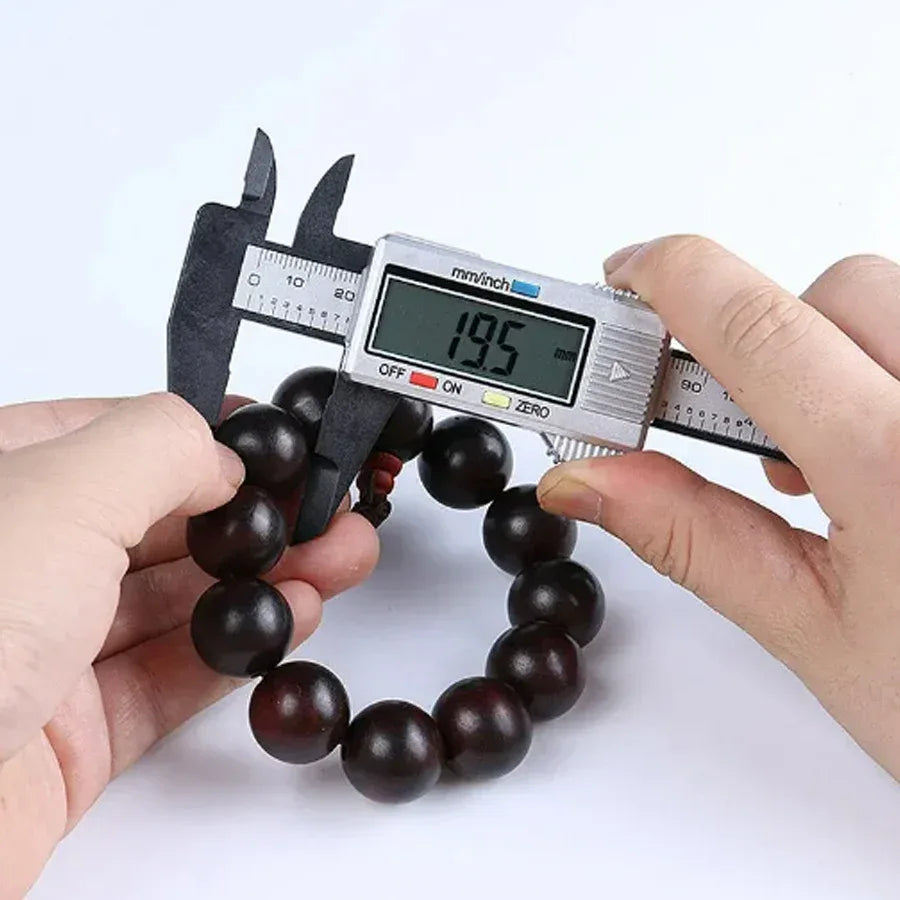 Mini vernier caliper positioned next to ruler displaying measurement readiness.