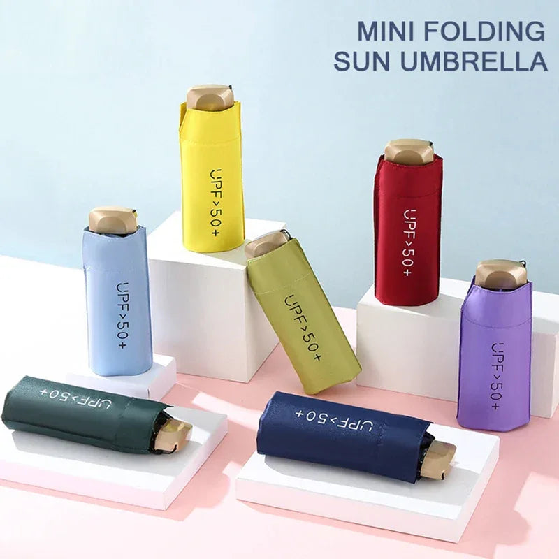 Mini folding umbrella carried in hand showing compact and portable design.