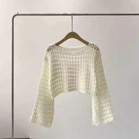 Close-up of white boho crochet knit crop top with intricate pattern details.