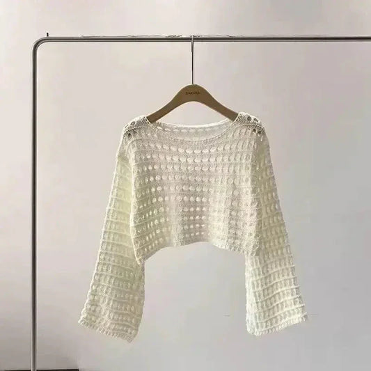 Close-up of white boho crochet knit crop top with intricate pattern details.
