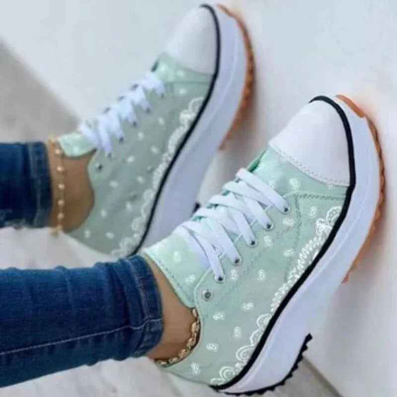 Trendy women’s canvas sneakers in white with a colorful 2022 pattern, shown with laces and a rubber sole.
