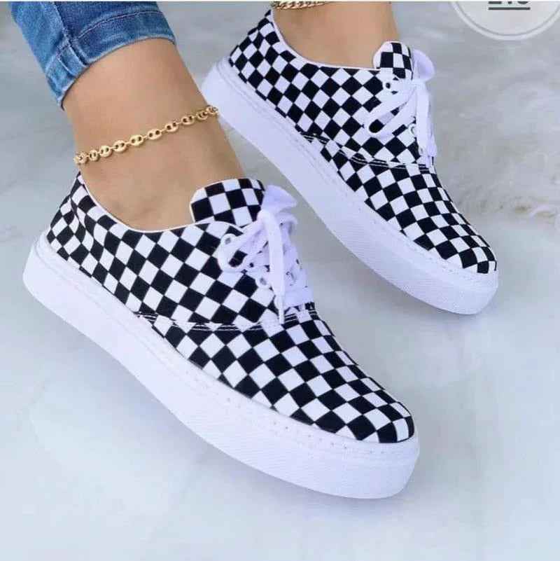 White women's sneakers with colorful graffiti designs, chunky soles, and lace-up fronts displayed on a neutral.