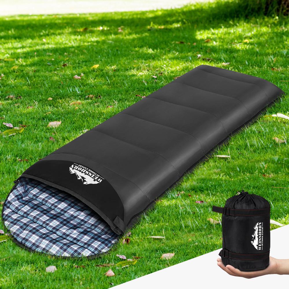 Top-down view of sleeping bag rolled for storage on a white surface