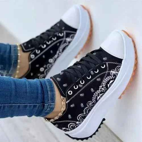 White canvas women's sneakers with a colorful 2022 pattern, lace-up design, and flat rubber sole.