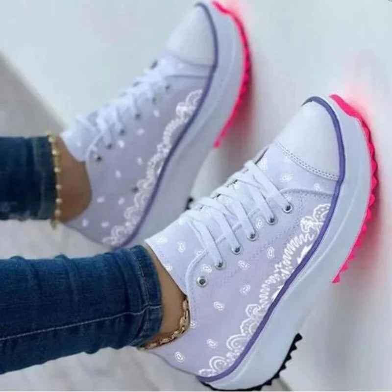 White canvas women’s sneakers with a colorful 2022 pattern, lace-up design, and flat rubber sole.