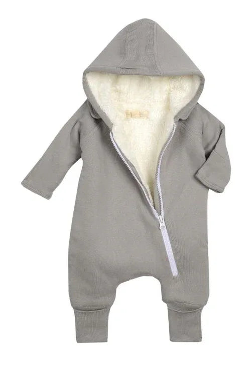 Baby lying down comfortably in gray fleeced jumpsuit with bib, hands and feet covered.